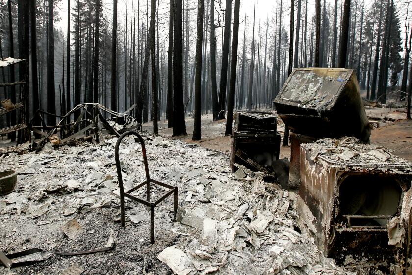 GRIZZLY FLATS, CALIF. - AUG. 18, 2021. A chairr stands in a charred home in Grizzly Flats, which was destroyed by the Caldor Fire on Wednesday, Aug. 18, 2021. (Luis Sinco / Los Angeles Times)