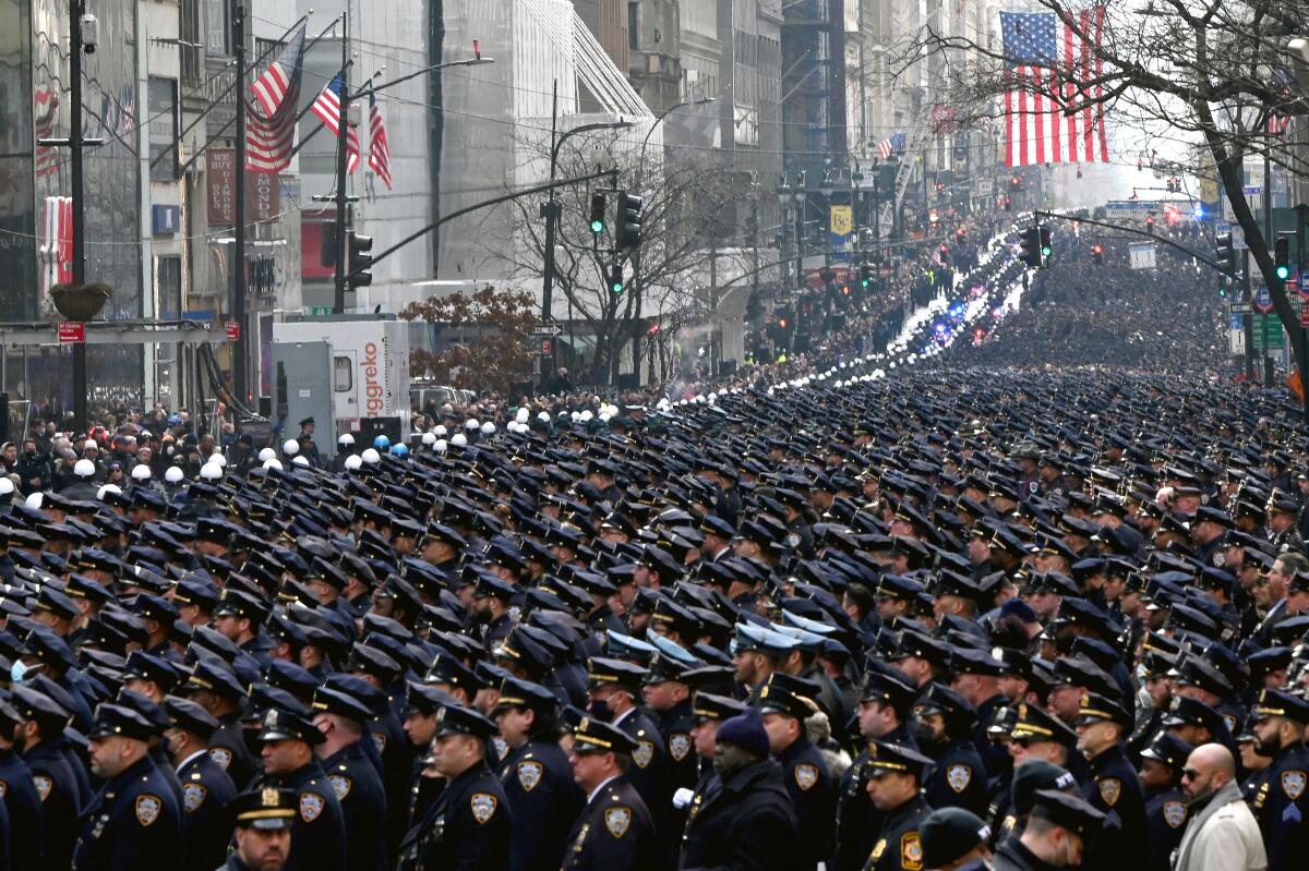 Thousands of uniformed police stand in the street outside New York's St. Patrick's Cathedral.