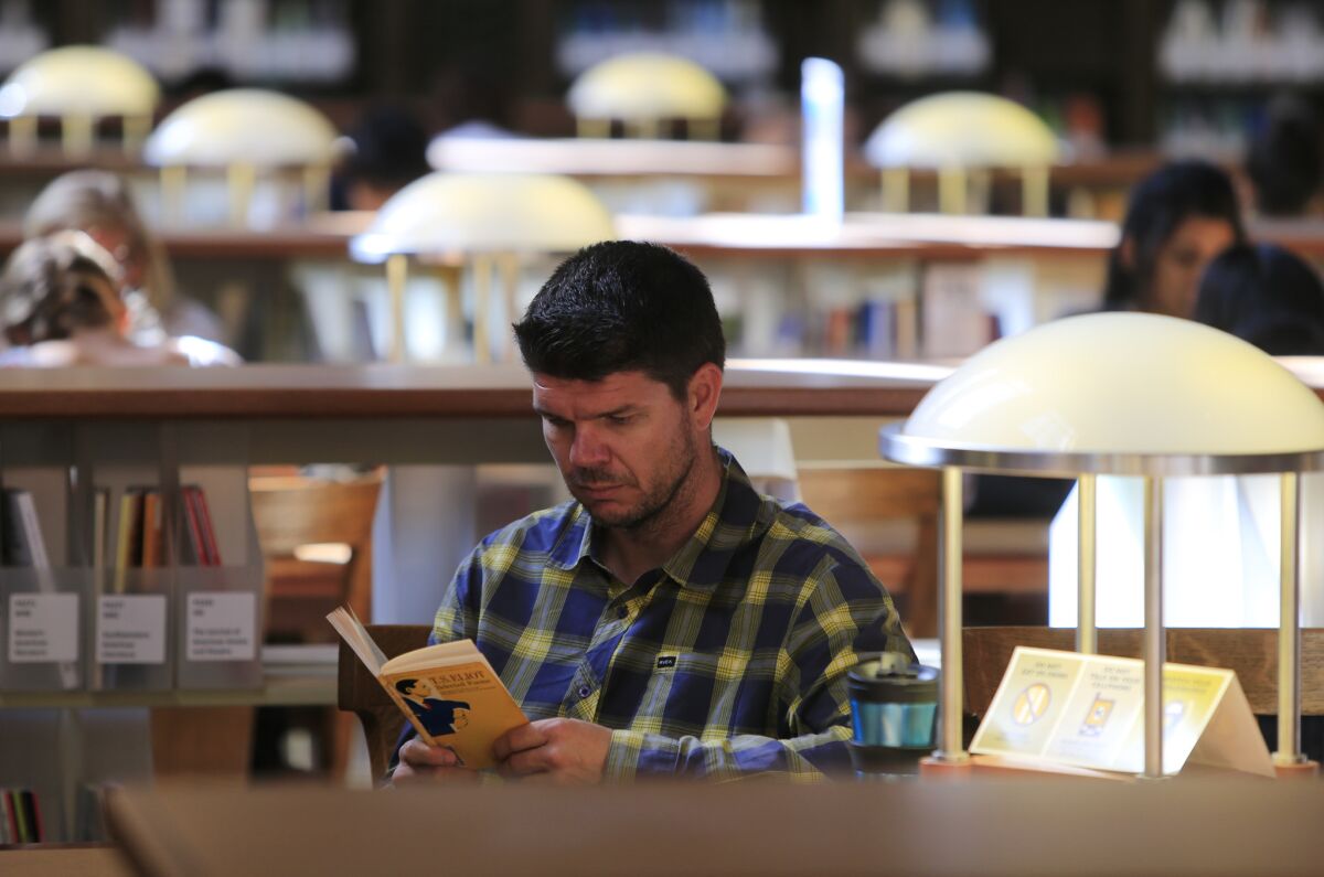 Steven Czifra reads in a UC Berkeley library.