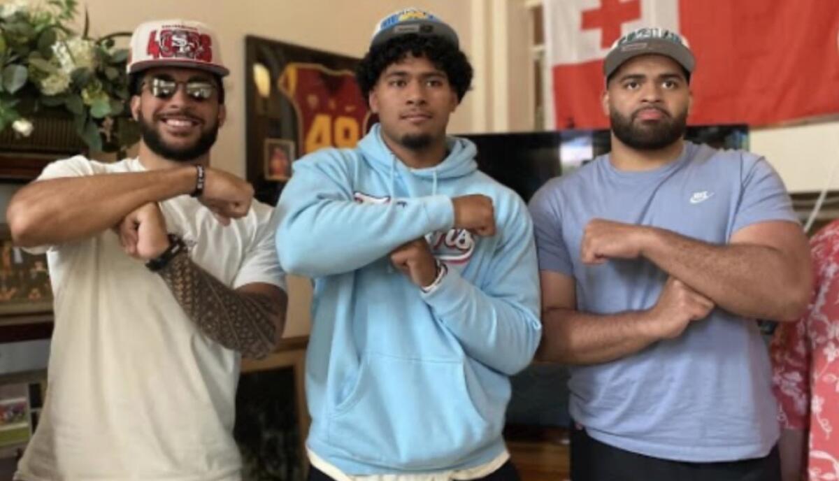 From left, Talanoa Hufanga, Tuli Tuipulotu and Marlon Tuipulotu all give the T signal, a celebratory tribute to Tonga.