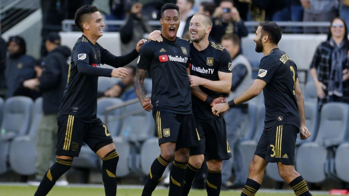 LAFC midfielder Mark-Anthony Kaye, second from left, celebrates his goal with teammates in the first half of a match.