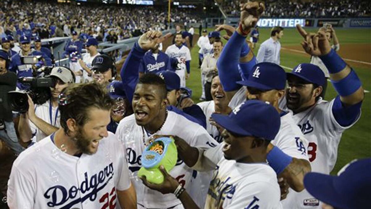 Dodgers ace Clayton Kershaw, left, is mobbed by his teammates after throwing a no-hitter against the Rockies on June 18, 2014. Most L.A. TV viewers couldn't watch the game.