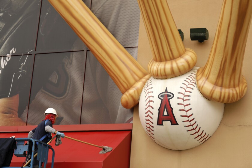 A worker washes an awning in front of Angel Stadium in Anaheim on Monday.