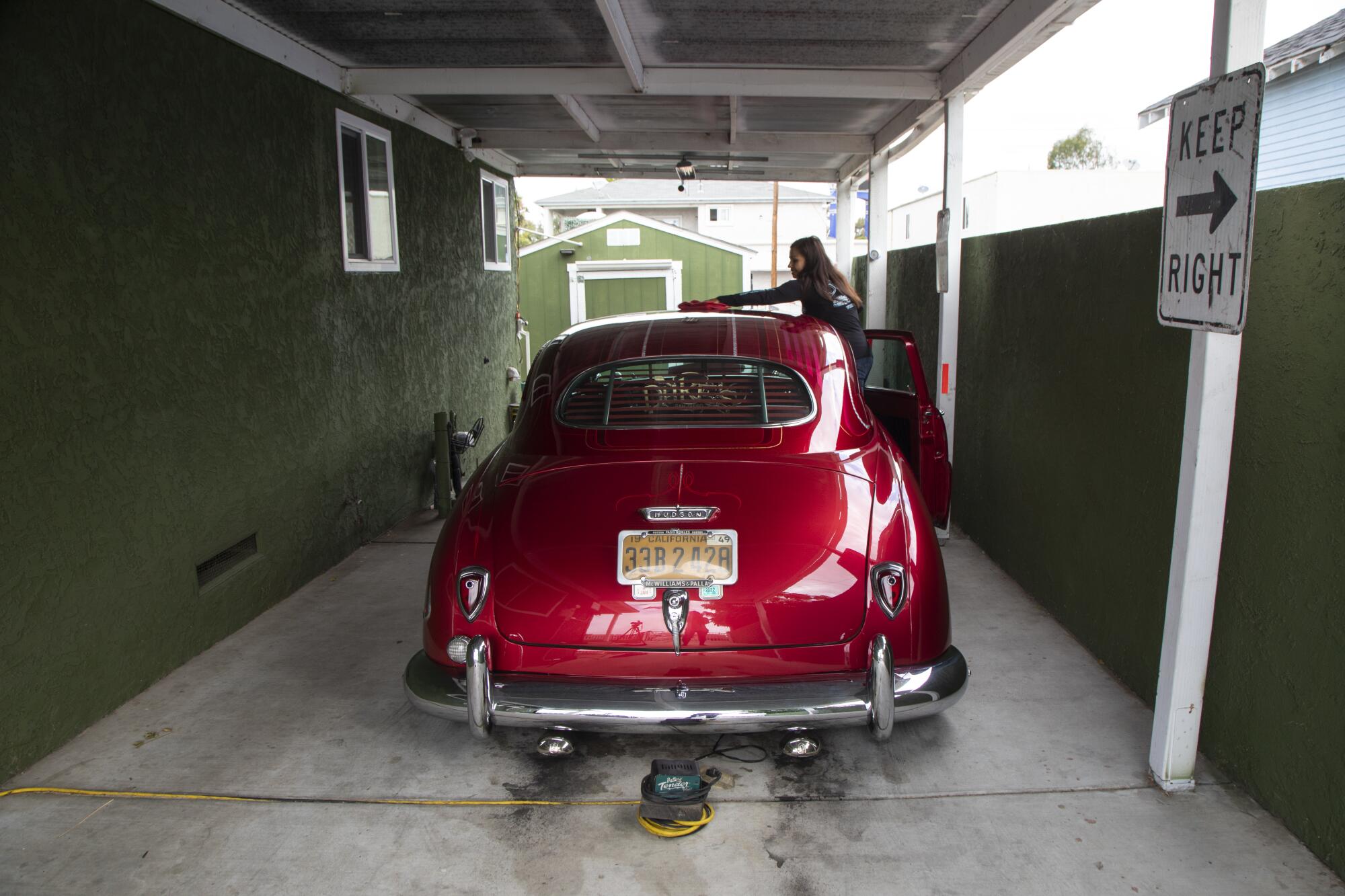 Marisa Rosales, a founding member of the United Lowrider Coalition, does a quick cleaning of her 1949 Hudson Brougham.
