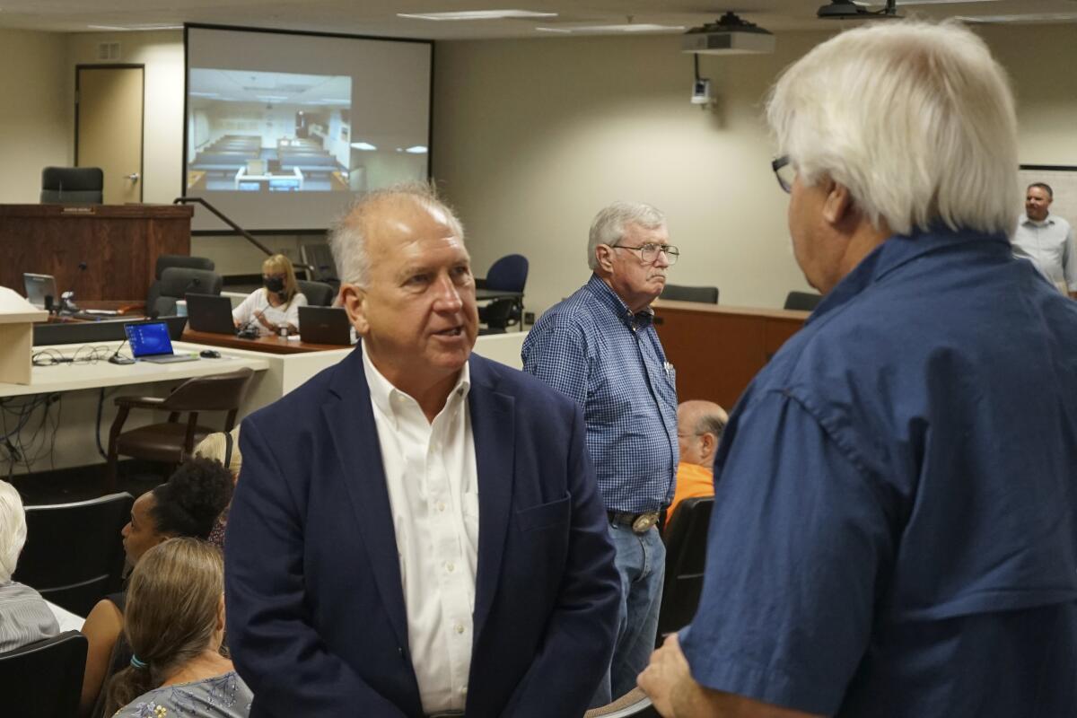 Mark Kampf speaks to a supporter at the Nye County Commission meeting on July 19, 2022, in Pahrump, Nev. County Commissioners voted to appoint Kampf to replace a longtime election official who resigned over the county's plan to transition to counting ballots by hand, without electronic voting machines. (AP Photo/Samuel Metz)