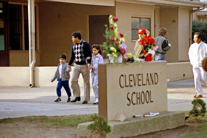 A man and two students arrive back at Cleveland Elementary School in Stockton, Calif., Jan. 17, 1989 after a heavily armed gunman invaded the school yard and killed five children and injured 30 others before killing himself. (AP Photo/Paul Sakuma)