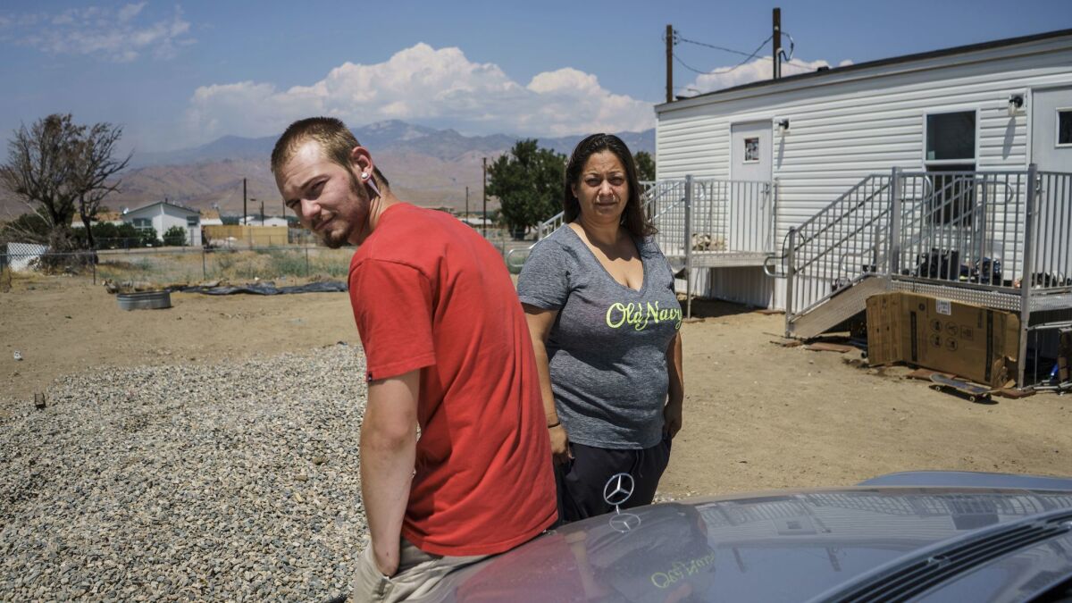 Melanie Perea and her boyfriend, Erik Kirby, outside their makeshift FEMA-provided trailer home in Lake Isabella.