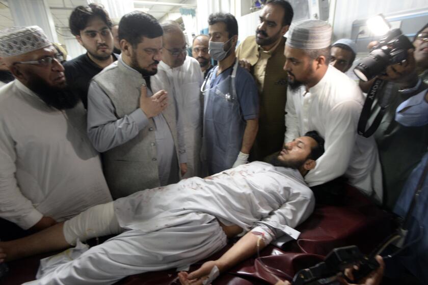 People transport an injured victim of a powerful bomb upon arrival at a hospital in Peshawar, Pakistan, Sunday, July 30, 2023. A bomb ripped through a rally by supporters of a hard-line cleric and political leader in the country's northwestern Bajur district that borders Afghanistan on Sunday, police and health officials said. (AP Photo/Muhammad Sajjad)