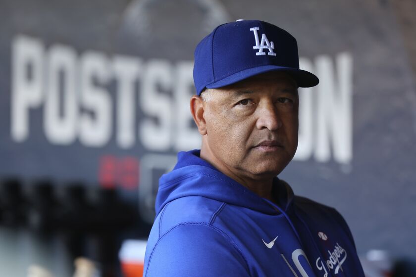 Los Angeles Dodgers manager Dave Roberts stands in the dugout 