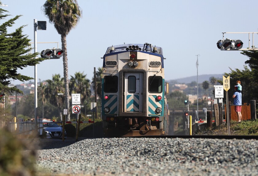 A Coaster train heads north in Del Mar, where North County Transit District plans to install a safety fence along the tracks.