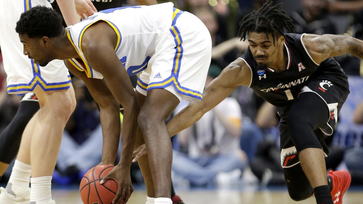 Cincinnati guard Jacob Evans tries to steal the ball from UCLA guard Isaac Hamilton during the first half.