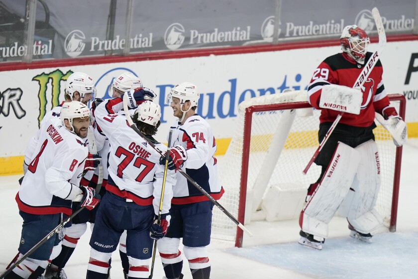 Washington Capitals' Alex Ovechkin (8) celebrates with teammates after scoring a goal as New Jersey Devils goaltender Mackenzie Blackwood (29) reacts during the second period of an NHL hockey game Sunday, April 4, 2021, in Newark, N.J. (AP Photo/Frank Franklin II)