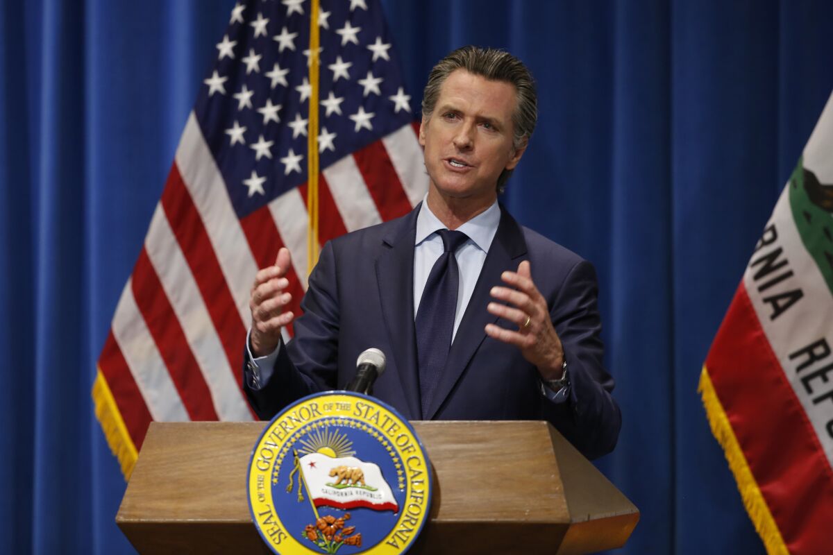 Gavin Newsom speaks at a podium that carries the seal of California.