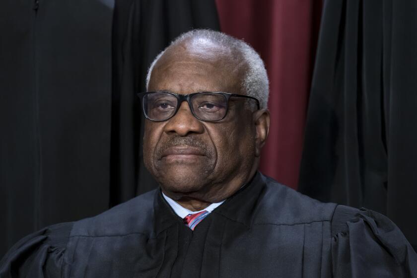 FILE - Associate Justice Clarence Thomas joins other members of the Supreme Court as they pose for a new group portrait, at the Supreme Court building in Washington, Oct. 7, 2022. Thomas is absent from the court Monday with no explanation. The 75-year-old Thomas also is not participating remotely in arguments, as justices sometimes do when they are ill or otherwise can’t be there in person. Chief Justice John Roberts announced Thomas’ absence, saying that his colleague would still participate in the day’s cases, based on the briefs and the transcripts of the arguments. (AP Photo/J. Scott Applewhite, File)