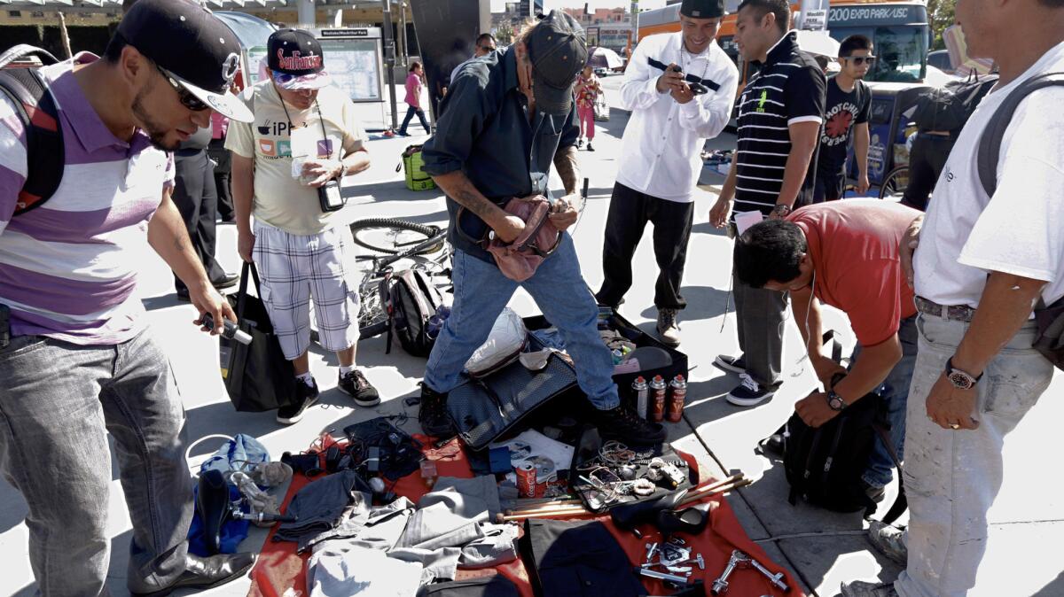 Kevin "Sippi" Moran, 49, center, in black baseball cap, sells his wares to a crowd of sidewalk shoppers along Alvarado Street in the Westlake neighborhood.