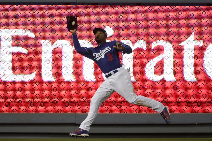 Dodgers left fielder Carl Crawford tracks down a fly ball hit by the Angels' Kole Calhoun during a Freeway Series game April 1.