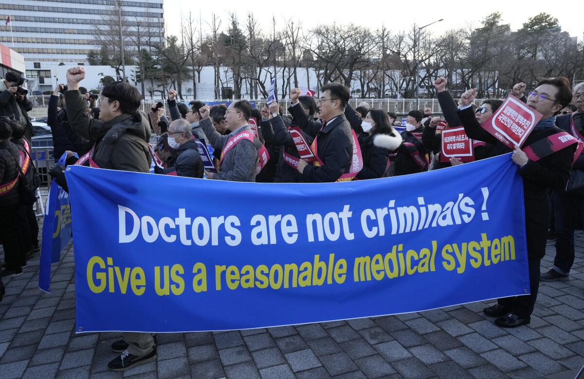 Doctors rally holding a banner reading "Doctors are not criminals!"