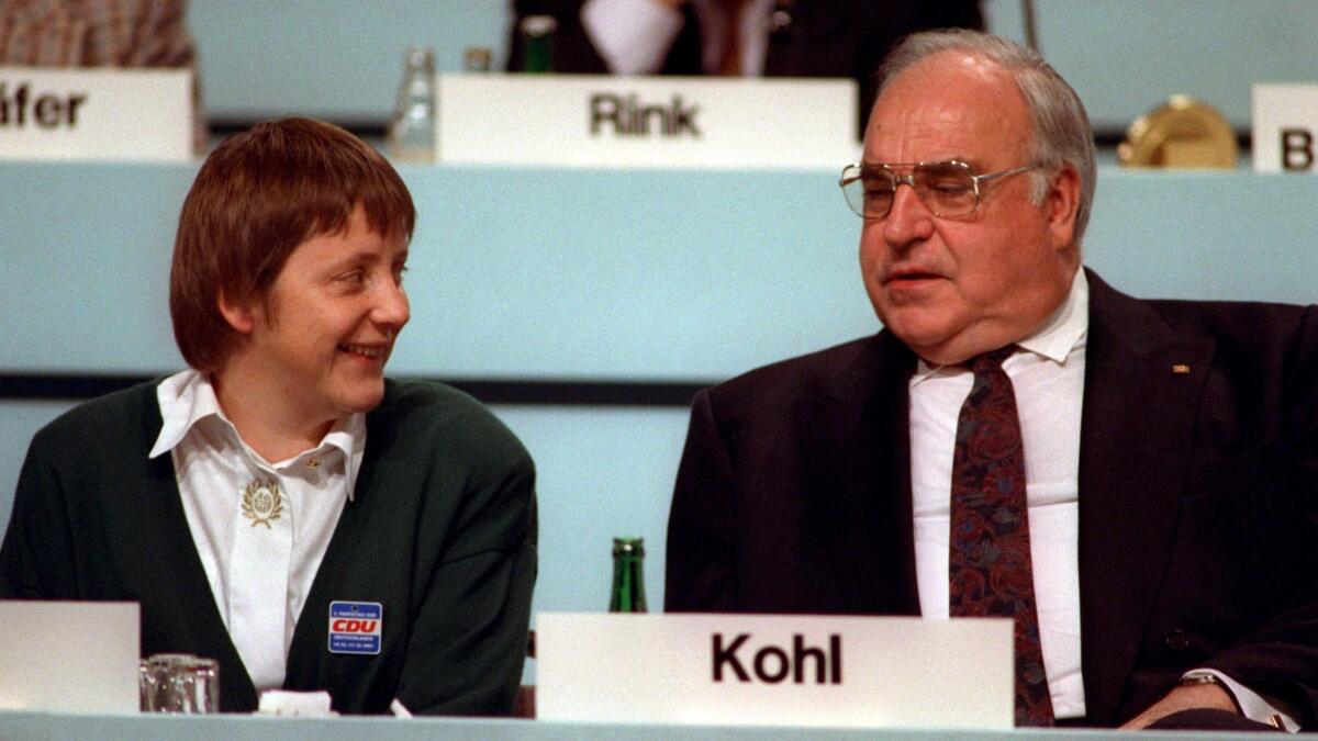 Then German Chancellor Helmut Kohl, right, and his newly elected Vice Chancellor Angela Merkel during a party conference in Dresden, Germany, on Dec. 16, 1991.