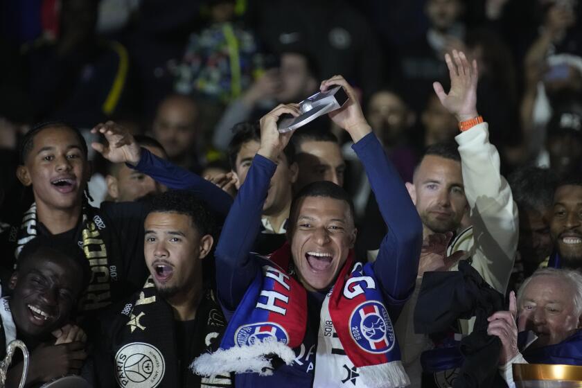 Kylian Mbappé celebra con sus compañeros del Paris Saint-Germain el título de la liga francesa, el domingo 12 de mayo de 2024, en París. (AP Foto/Christophe Ena)