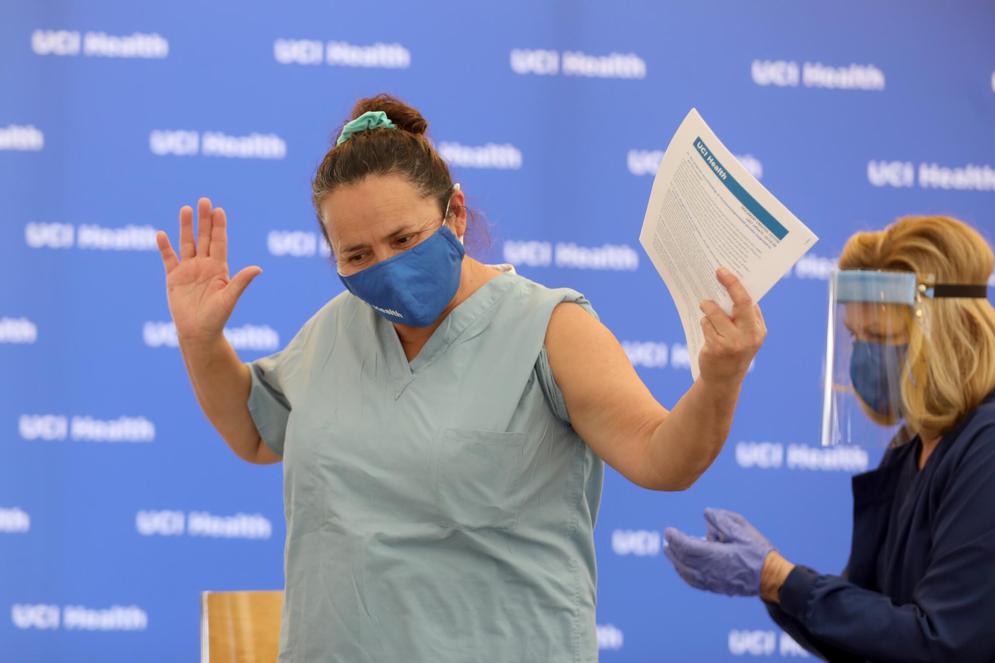 Martha Siqueiros, who works in housekeeping at UCI Health, celebrates after receiving a Pfizer BioNTech COVID-19 vaccine.