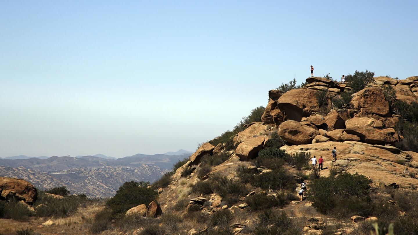 Photographed from the junction of the Hummingbird trail and the Rocky Peak trail, hikers climb the rocks off of the Hummingbird trail.
