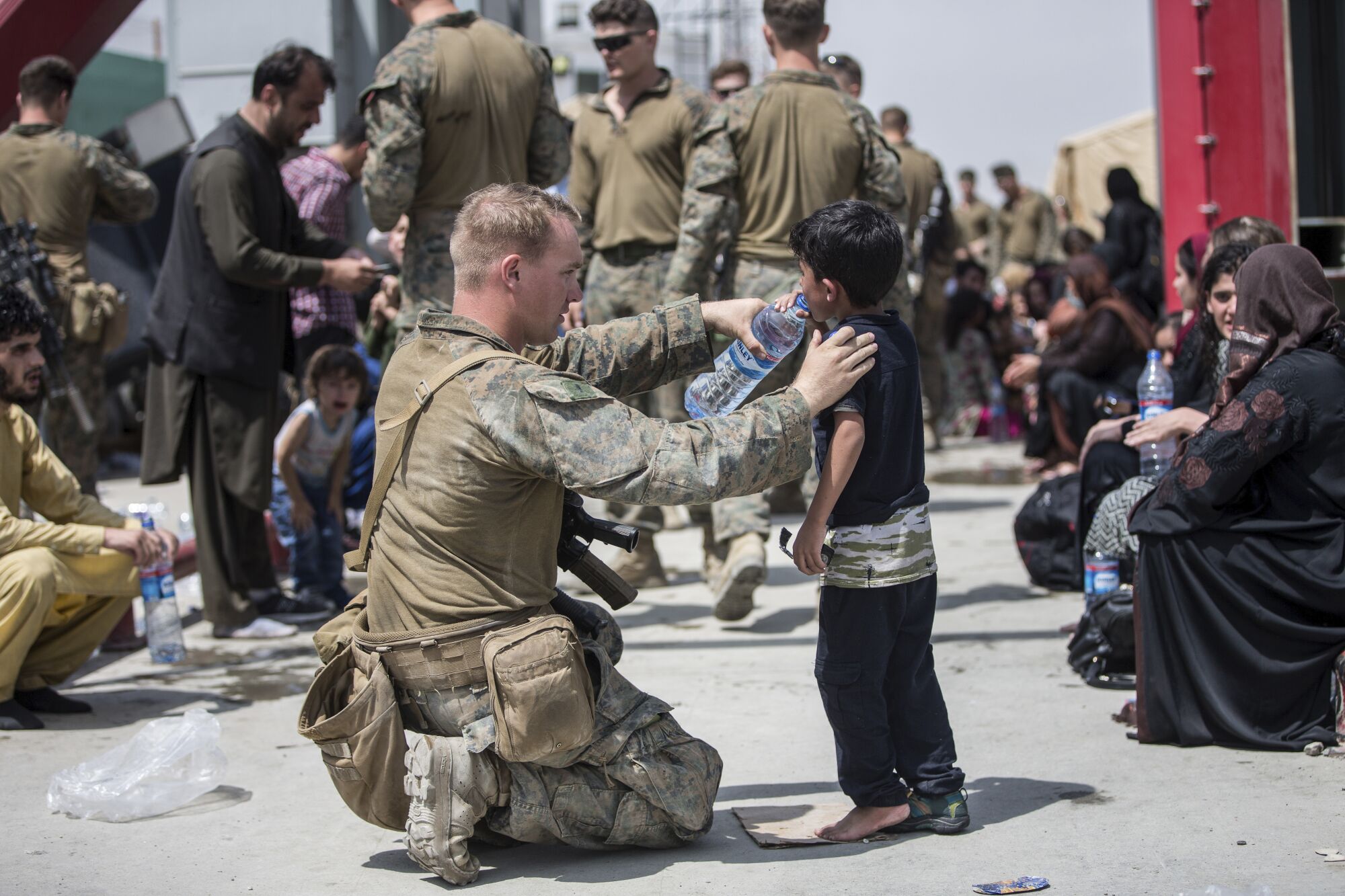 A U.S. Marine with the 24th Marine Expeditionary Unit (MEU) provides fresh water to a child during an evacuation