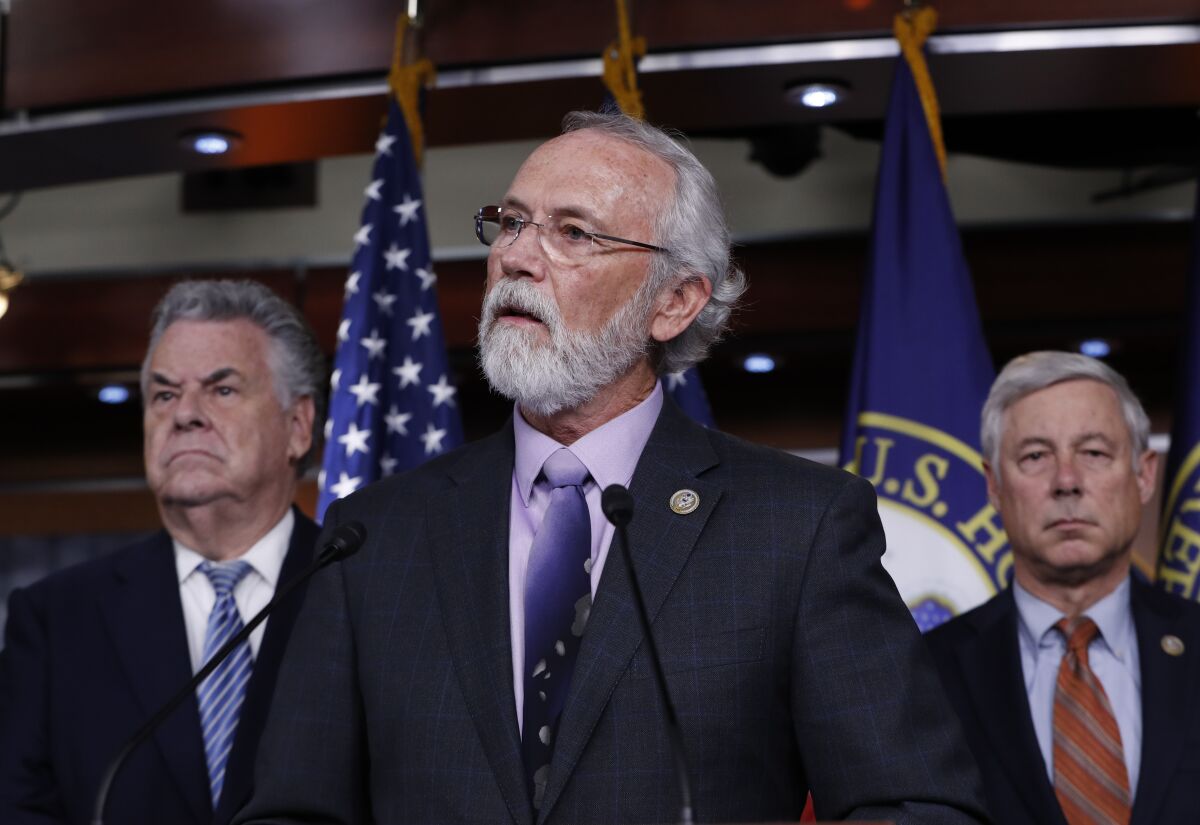 Rep. Dan Newhouse, flanked by Reps. Peter King and Fred Upton speaks into a microphone.