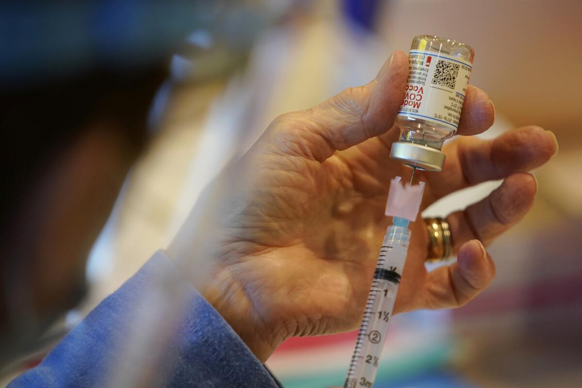 A medical worker fills a syringe with the Moderna COVID-19 vaccine.