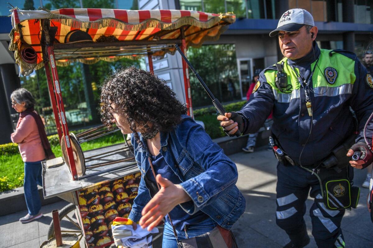 A Turkish police officer strikes a protester attempting to defy a ban and march on Taksim Square in Istanbul.