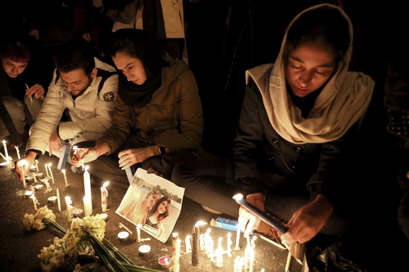 People gather for a candlelight vigil to remember the victims of the Ukraine plane crash, at the gate of Amri Kabir University that some of the victims of the crash were former students of, in Tehran, Iran, Saturday, Jan. 11, 2020. Iran on Saturday, Jan. 11, acknowledged that its armed forces "unintentionally" shot down the Ukrainian jetliner that crashed earlier this week, killing all 176 aboard, after the government had repeatedly denied Western accusations that it was responsible. (AP Photo/Ebrahim Noroozi)