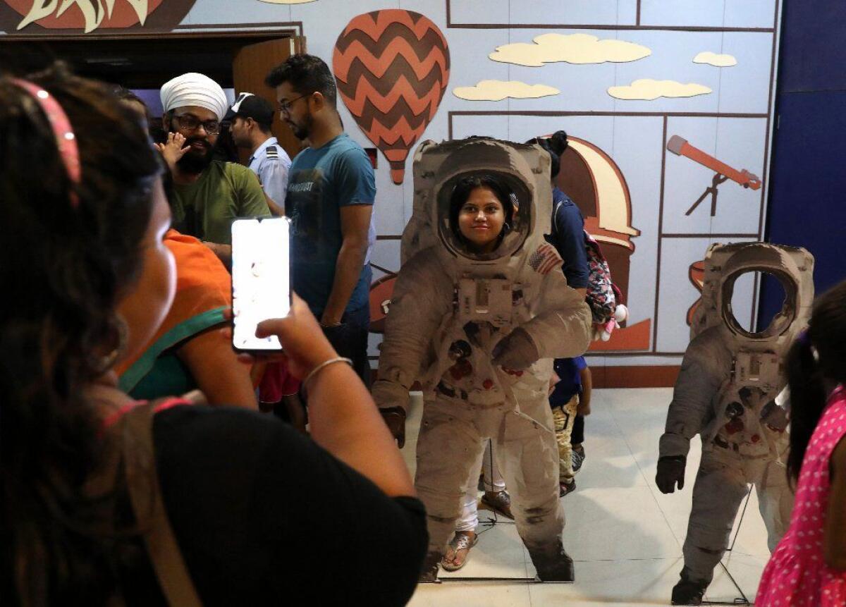 An Indian poses in a cutout of an astronaut at Nehru Planetarium in New Delhi.