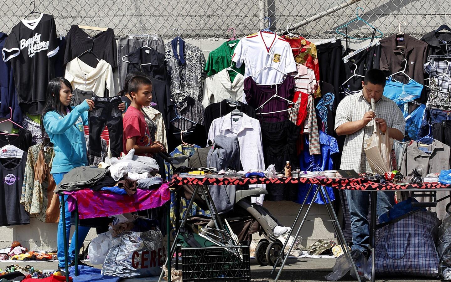 Shoppers check out items for sale in a Watts neighborhood. A proliferation of unlicensed street vending and people illegally selling used items out of their homes or at informal open-air markets are becoming neighborhood nuisances -- and worse, according to some officials.
