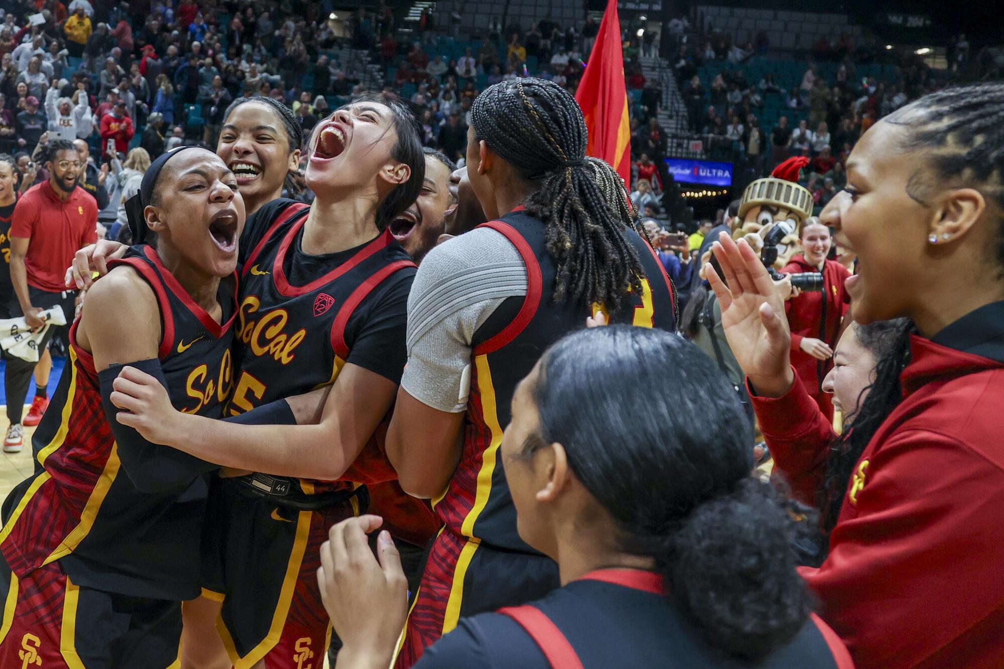 USC's Kayla Williams, left, and Kayla Padilla, second from left, celebrate after the Trojans defeat top-seeded Stanford.