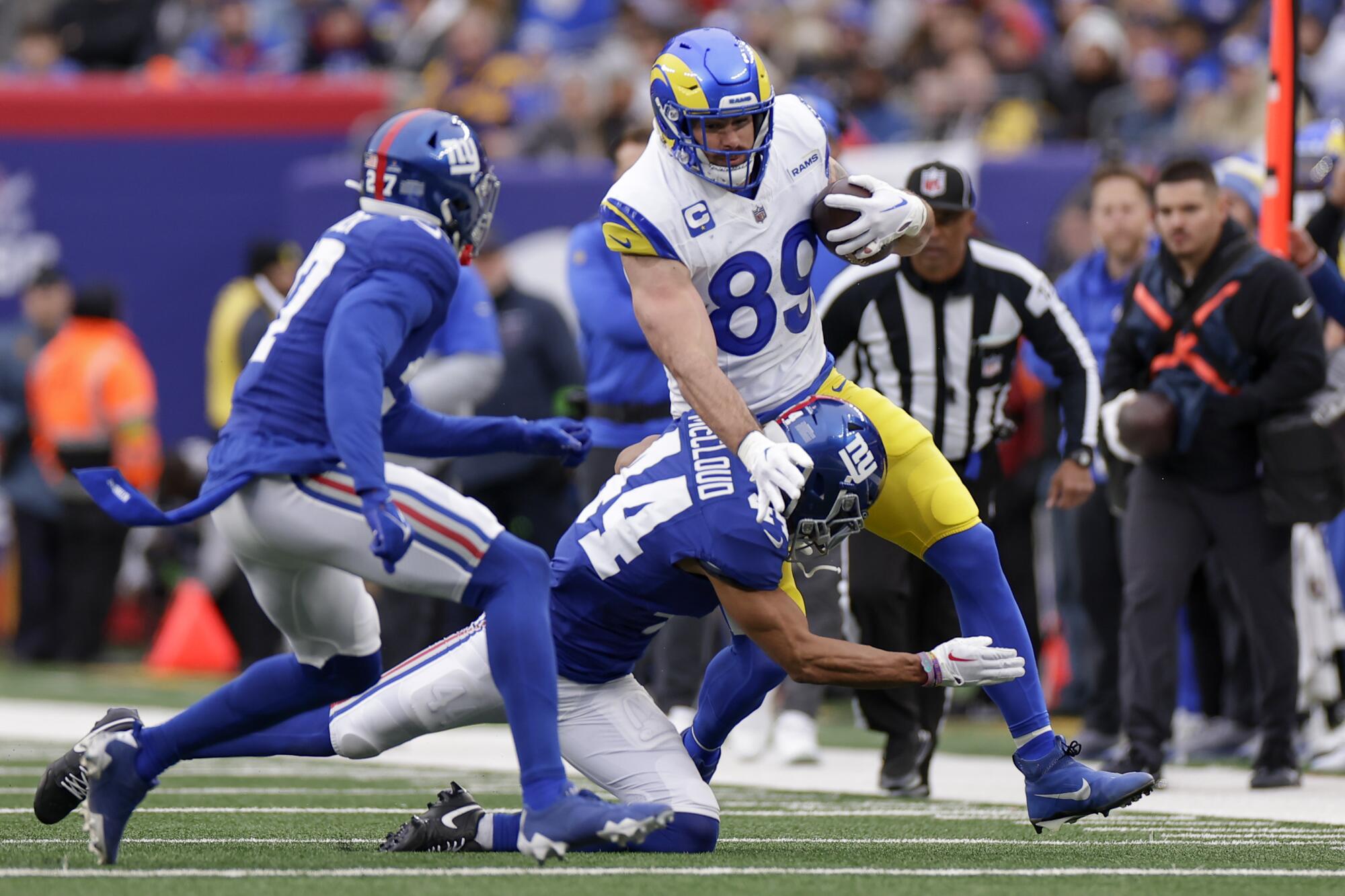 Rams tight end Tyler Higbee runs with the ball as New York Giants cornerback Nick McCloud tries to tackle him.