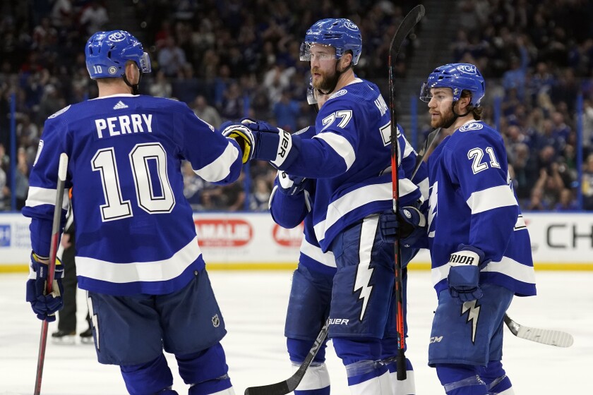 Tampa Bay Lightning center Brayden Point (21) celebrates his goal against the Detroit Red Wings with defenseman Victor Hedman (77) and right wing Corey Perry (10) during the second period of an NHL hockey game Friday, March 4, 2022, in Tampa, Fla. (AP Photo/Chris O'Meara)