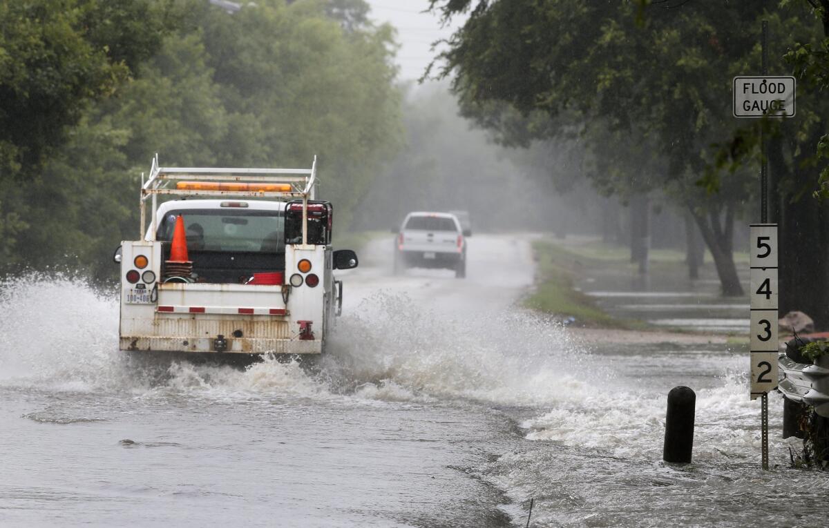 Drivers navigate a road closed due to high water after a morning of rain showers Wednesday in Irving, Texas. Authorities warned Wednesday that as Tropical Depression Bill moves northeast, already swollen rivers could overflow their banks and cause more problems for water-weary residents.