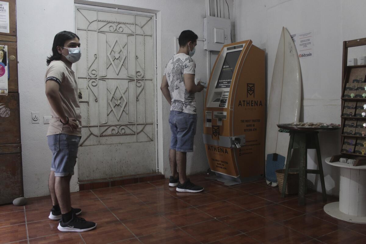 Eduardo Magaña (derecha) utiliza el primer cajero automático diseñado para retirar efectivo 