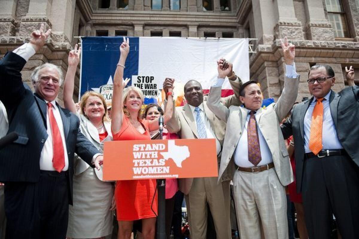 Democratic Texas representatives cheer during a women's rights rally before a Special Session of the Texas Legislature in Austin.