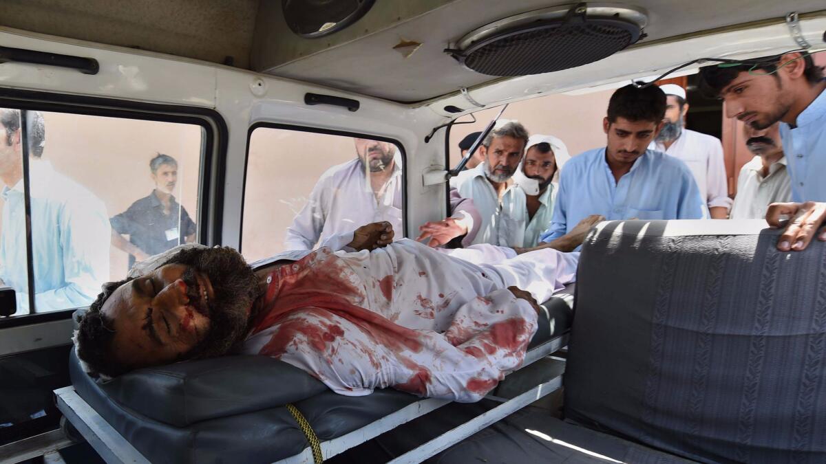 An injured man is loaded onto a van for transport after a suicide bomb attack at a district court in Mardan, Pakistan, on Sept. 2.