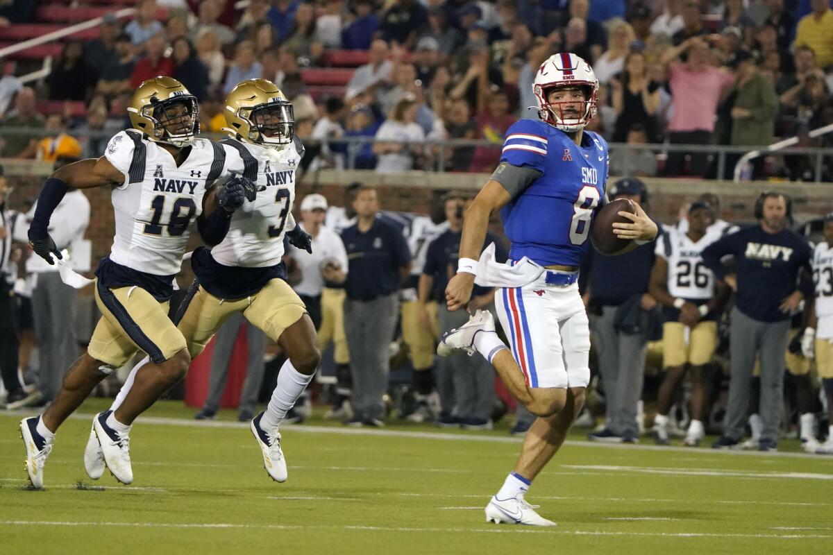 SMU quarterback Tanner Mordecai (8) rushes for a touchdown against Navy defender Rayuan Lane III (18) and Elias Larry (3) during the third quarter of an NCAA college football game in Dallas, Friday, Oct. 14, 2022. (AP Photo/LM Otero)