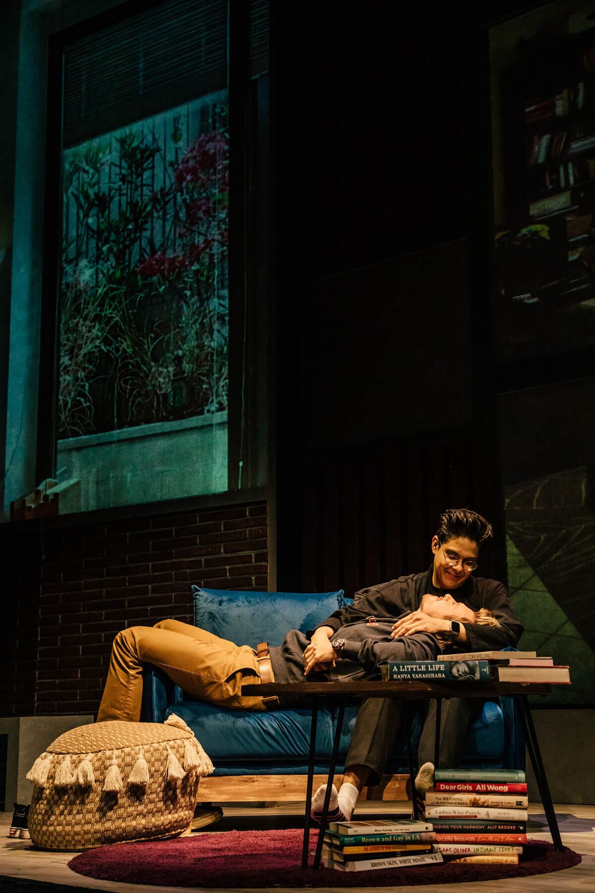 man holds another man on the couch
