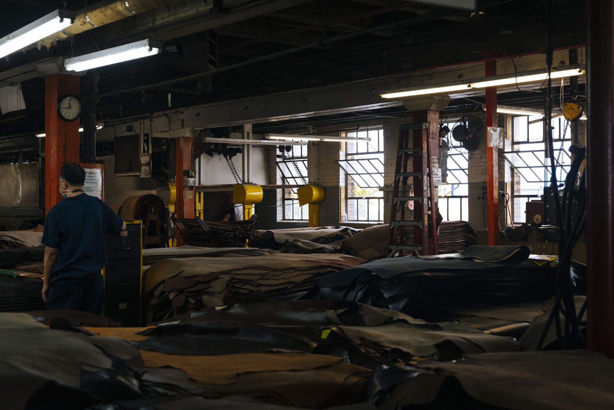 A worker walks among stacks of leather at the Horween Leather Company.