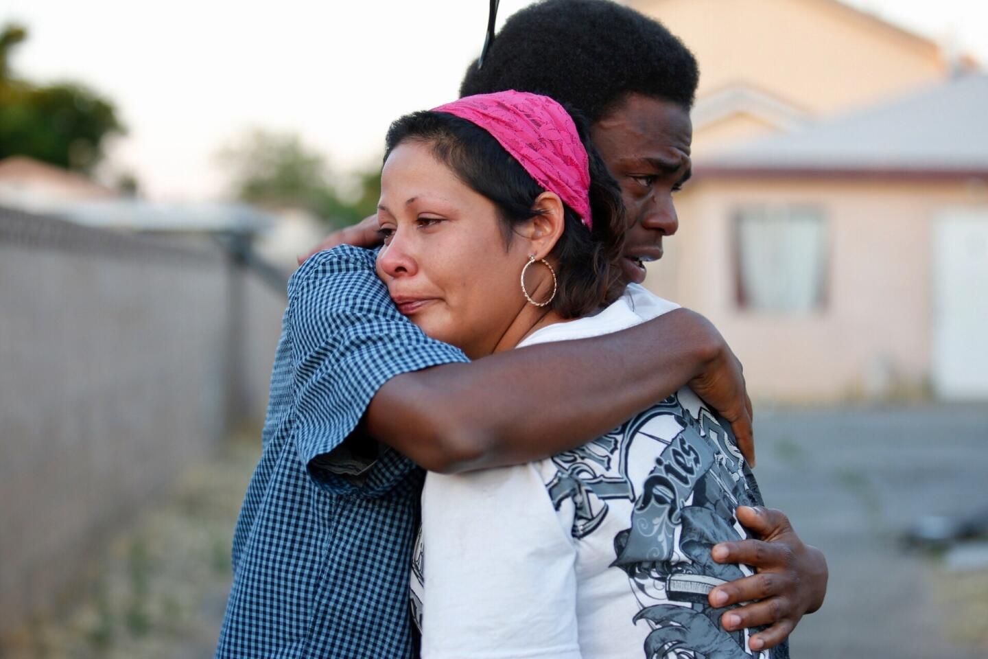 Roberta Alcantar, mother of the victim, hugs her son's friend Miles Mooreand at a candlelight vigil for teenager Armando Garcia-Muro in Palmdale.