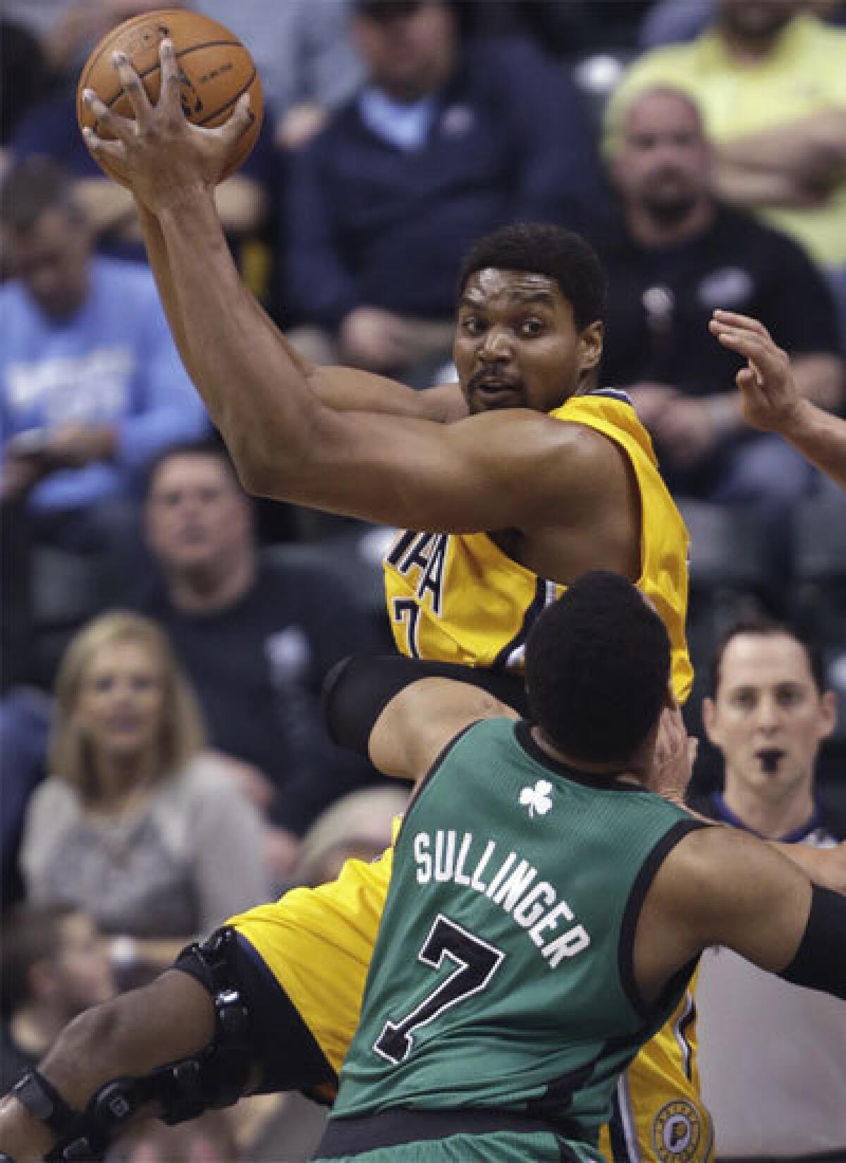 Indiana center Andrew Bynum pulls down a rebound in front of Boston's Jared Sullinger.