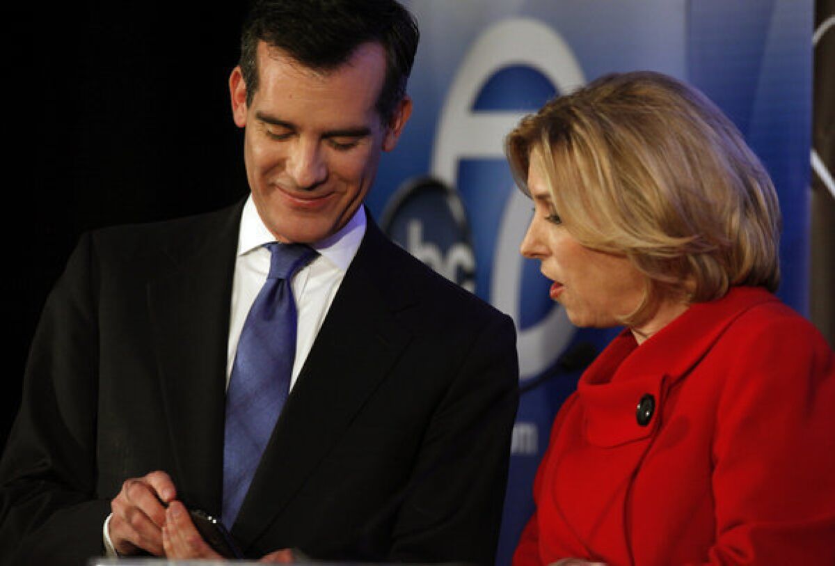 Candidates for Los Angeles mayor Eric Garcetti and Wendy Greuel talk on stage before a debate at Cal State L.A.'s Pat Brown Institute of Public Affairs.