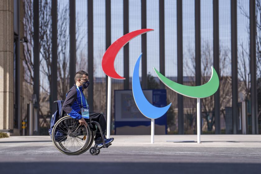 El italiano Matteo Remotti Martini pasa en silla de ruedas por delante del logo paralímpico en la Villa Paralímpica, antes de los Juegos Paralímpicos de Invierno de Beijing 2022, en Beijing, China, el 3 de marzo de 2022. (Thomas Lovelock/OIS via AP)
