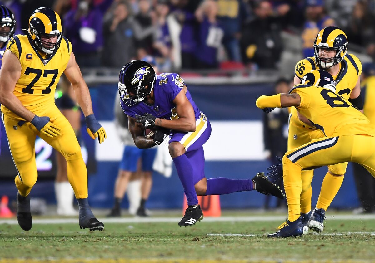 Ravens cornerback Marcus Peters returns an interception against Rams during the fourth quarter of a game Nov. 25 at the Coliseum.
