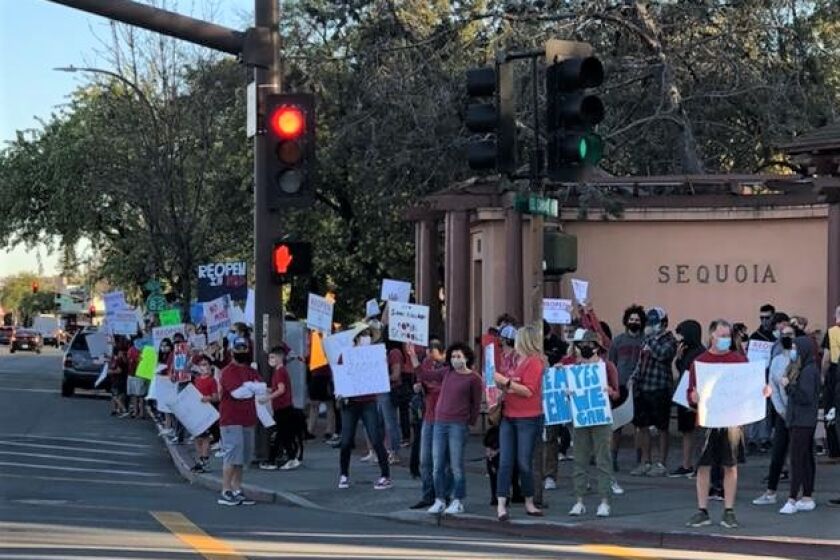 Parents demonstrate outside of the Sequoia Union High School District offices, in Redwood City, Tuesday, Feb. 23 as part of a campaign to pressure the district to reopen schools for on-campus learning.