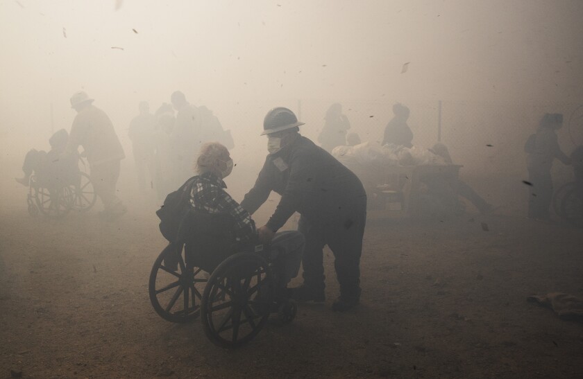 Healthcare workers evacuate residents from the Riverside Heights Healthcare Center in Jurupa Valley