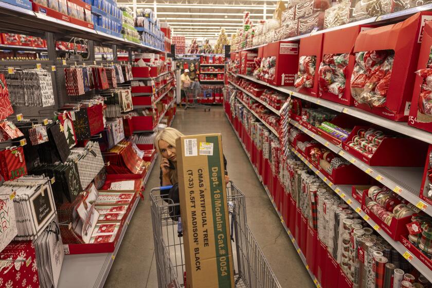 Burbank, CA - November 14: A customers rolls her cart past shelves stocked with holiday items and Black Friday deals at the Walmart Supercenter on Tuesday, Nov. 14, 2023 in Burbank, CA. (Brian van der Brug / Los Angeles Times)
